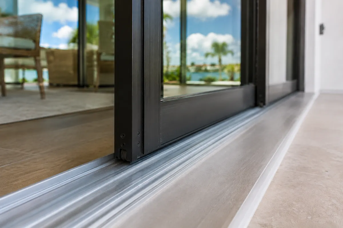 Close-up of sliding glass door rollers and track